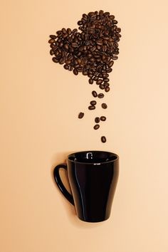 coffee beans falling out of a black cup