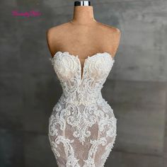 the back of a white wedding dress with sheer lace and appliques on it