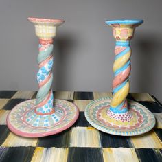 two colorful candlesticks sitting on top of a table