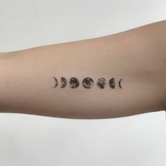 a person's arm with four phases of the moon on it, all in black and white