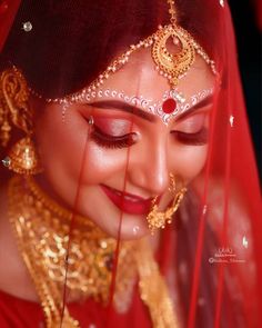 a woman wearing a red veil and gold jewelry