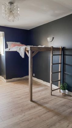 a loft bed with ladders in the middle of a room that has blue walls and wood flooring