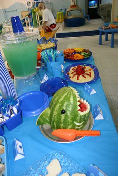 a blue table topped with watermelon and other food