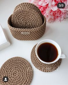 there are two crocheted coasters next to a cup of coffee