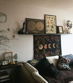 a living room filled with lots of furniture and pictures on the wall above it's headboard