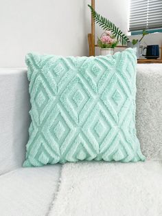 a blue pillow sitting on top of a white couch