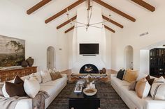 a living room filled with furniture and a fire place in the middle of an open floor plan