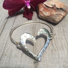 "Hammered heart bangle bracelet. Sterling silver. Hand made. Made with solid half round SS wire. Hammered heart is 1 3/8\" x 1 1/2\" Custom orders accepted" Sterling Silver Heart Bangle For Valentine's Day, Silver Heart-shaped Nickel-free Bracelet, Silver Nickel Free Heart Bracelet, Hand Forged Silver Heart Jewelry, Valentine's Day Sterling Silver Heart Bangle, Metal Heart Bangle Bracelet For Anniversary, Heart-shaped Sterling Silver Bracelet For Weddings, Adjustable Silver Heart Bangle Bracelet, Adjustable Sterling Silver Heart Bangle Bracelet