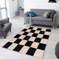 a black and white checkered rug in a living room with two gray couches