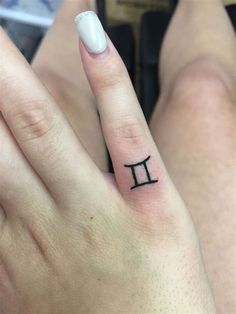 a woman's hand with a small pi symbol tattoo on her left thumb and finger