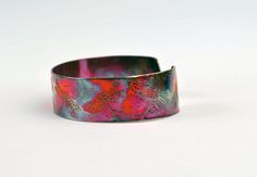 This etched copper dragonfly bangle bearing imagery of repeated dragonflies has been heat treated to create a vibrant multicoloured patina: this will deepen over time. I have developed a technique of literally 'painting' with a flame to manipulate the shape and direction of the colours. Although there is a degree of control, each piece is unique, as the colour patina cannot be replicated exactly. In holistic medicine, copper claims to have many health benefits: 'Copper has been used to promote h Dragonfly Gifts, Dragonfly Bracelet, Copper Jewellery, Etched Copper, Copper Cuff, Handmade Bangles, Holistic Medicine, Patterns In Nature, Bracelet Handmade