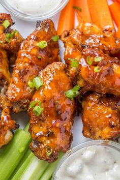 chicken wings with celery, carrots and ranch dressing on a plate next to celery sticks