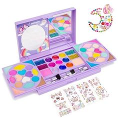 an open purple box filled with lots of different colored paints and stickers next to it's contents