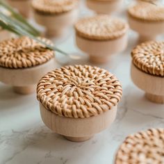 small round wicker boxes sitting on top of a marble counter with flowers in the background