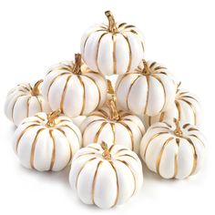 white pumpkins stacked on top of each other with gold trim around the tops and sides