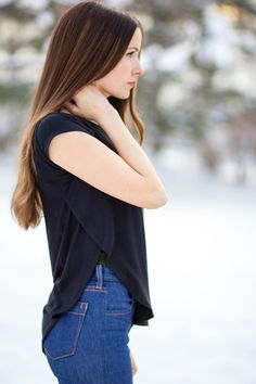 a woman standing in the snow with her hand on her neck