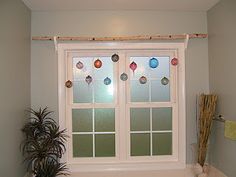 a bath room with a tub and a window next to a potted palm tree