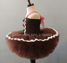 This adorable gingerbread tutu dress features brown glitter tulle and frosting! The straps are adjustable by tightening the bow in the back. Skirt length: 0-6 months is approximately 4 inches long. 6 mos - 2T is approximately 6 inches long. 3-4T is approximately 8 inches long. 5-6T is approximately 10 inches long.Skirt length: 3-9 months is approximately 4 inches long. 9-24 months is approximately 5 inches long. 3/4T is approximately 6 inches long. 5/6T is approximately 8 inches long. Cute Fitted Christmas Tutu Dress, Cute Fitted Tutu Dress For Christmas, Fitted Tulle Tutu Dress For Holiday, Cute Fitted Tutu Dress For Festive Occasions, Cute Fitted Tutu Dress For Festivities, Brown Glitter, Tutu Dress, Skirt Length, Long Skirt