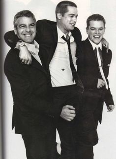 three men in suits are posing for the camera