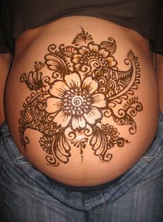 a woman's stomach with henna tattoos on it, and the bottom half of her belly