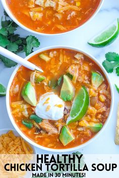 two bowls of mexican chicken soup with sour cream and tortilla chips on the side