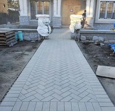 a man is walking down the sidewalk in front of a house that's being built