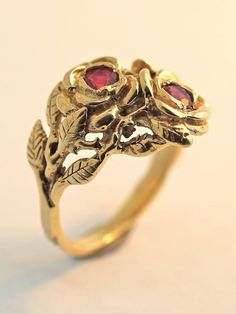 Two detailed roses make up this elegant ring, their stems entwining and forming the band. The ring is cast in solid 14K gold and two 3 mm rubies are set in the center of each rose. Indulge yourself or someone special in this sparkling bouquet. We will contact you to let you know if we have your chosen ring size in stock or when to expect shipment. All Marty Magic Jewelry is packaged in a beautiful ring box embossed with the gold foil Marty Magic dragon logo. Perfect for any occasion! Designed in Vintage Yellow Gold Flower Ring, Vintage 14k Gold Flower Ring For Anniversary, Vintage 14k Gold Flower Ring, Formal Flower Shaped Rings With Rose Design, Formal Flower-shaped Ring With Rose Design, Formal Flower-shaped Rose Design Ring, Formal Flower Shape Rose Design Ring, Vintage 14k Gold Flower Ring For Formal Occasions, Vintage Rose Jewelry For Anniversary