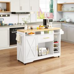 a kitchen with white cabinets and wood flooring, an island in the middle has food on it