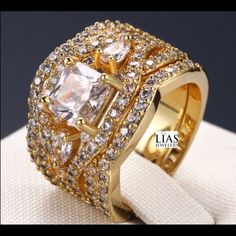 a gold ring with two rows of diamonds on top of it and the center surrounded by smaller stones