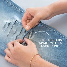 a woman is cutting through the holes in her jean's pants with a pair of scissors