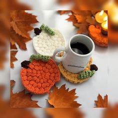 two crocheted coasters sitting on top of each other next to a cup of coffee