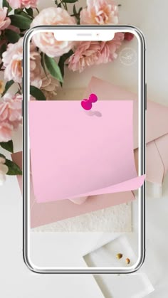 an image of a pink sticky note on a phone screen with flowers in the background