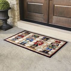 a door mat on the ground next to a potted plant and brown wooden doors