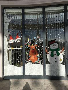 two frosted glass windows with christmas decorations on them and snowmen in the background