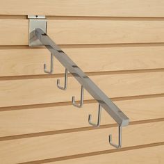 two metal hooks are attached to the side of a wooden wall with wood slats