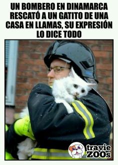 a man holding a white cat in his arms and wearing a fireman's hat