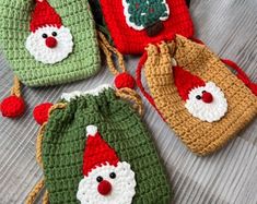 four crocheted bags with santa hats on them