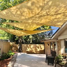 a patio covered in yellow shade next to a house