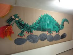 a wall hanging made out of legos with a green dragon on it's back