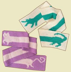 three knitted scarves with green and white designs on them, one has a dinosaur