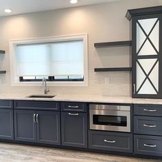 a kitchen with gray cabinets and white counter tops