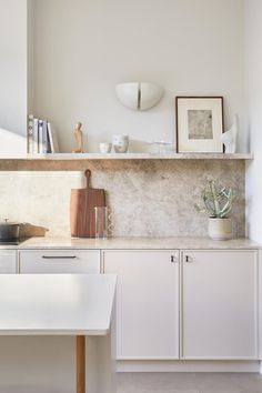 a kitchen with white cabinets and counter tops