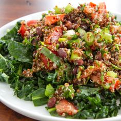 a white plate topped with salad on top of a wooden table