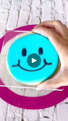 a person holding a cookie with a smiley face on it