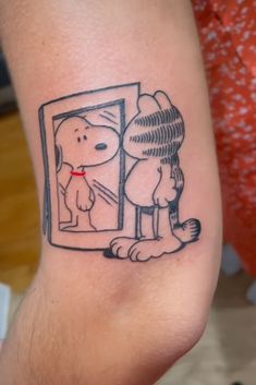 a person with a tattoo on their arm and dog looking in the mirror at himself