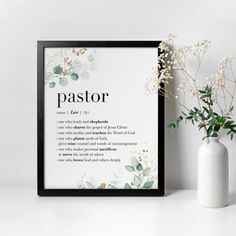 a white vase with flowers next to a black framed poster that says pastor on it