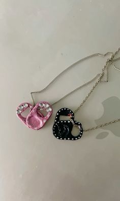 two necklaces that have been made to look like baby shoes and hearts on them