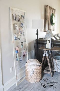 a living room filled with furniture and pictures hanging on the wall next to a lamp