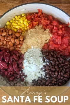 a bowl filled with beans, corn, and seasoning on top of a wooden table