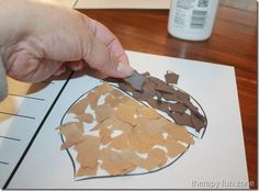 a person cutting out pieces of paper on top of a piece of paper with scissors